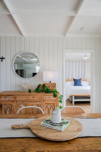 a room with a table with a mirror and a bed at Metung Holiday House in Metung