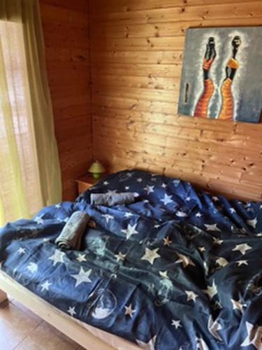 a bedroom with a bed with a blue comforter at Luis Apartman in Balatonboglár