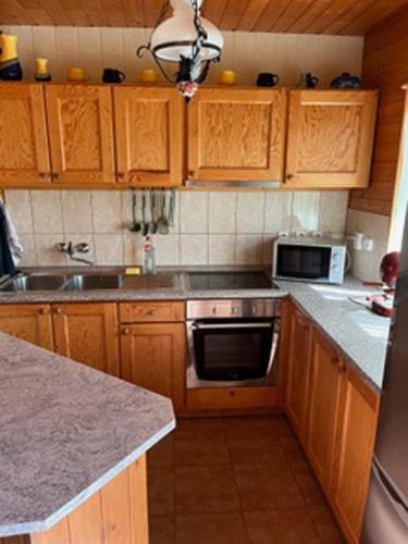 a kitchen with wooden cabinets and a stove top oven at Luis Apartman in Balatonboglár