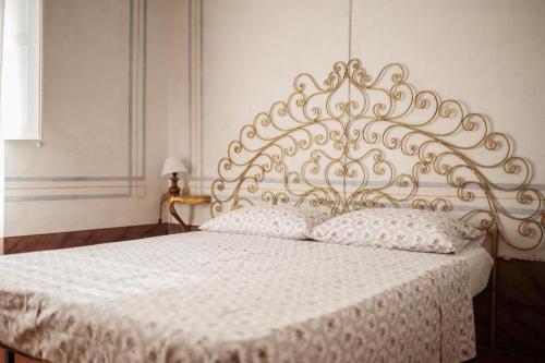 a bedroom with a white bed with a metal headboard at Villa Maddalena - Cerrolungo in Isola