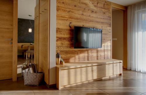 a living room with a tv on a wooden wall at Landhaus Freiburgerhof Wohnung 2 in Rifiano
