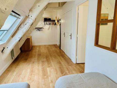 an attic room with a staircase and a bedroom at L'Attic, appartement au cœur de Cancale in Cancale