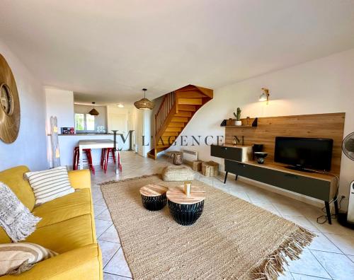 un salon avec un canapé et une télévision dans l'établissement Appartement Manuro Paisible & vue mer CALVI, à Calvi