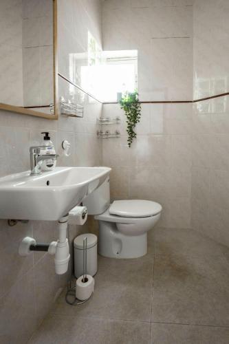 a white bathroom with a sink and a toilet at Cosy 1 bed pool house in Albir