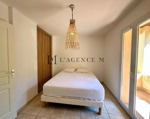 - une petite chambre avec un lit et un lustre dans l'établissement Appartement Manuro Paisible & vue mer CALVI, à Calvi