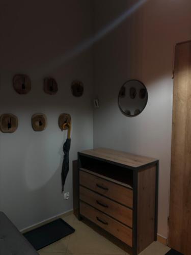 a bedroom with a dresser and an umbrella on the wall at DiDi Apartament Centrum in Nowy Targ