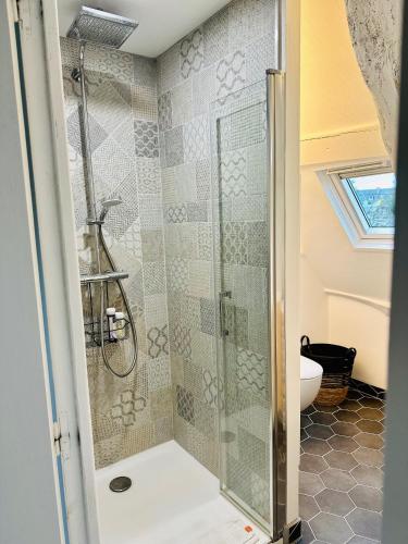 une douche avec une porte vitrée dans une salle de bain dans l'établissement L'Attic, appartement au cœur de Cancale, à Cancale