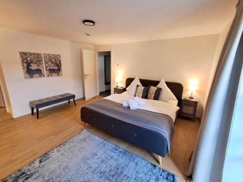 a bedroom with a bed and a bench in it at Ferienwohnung Alpenherz Berchtesgaden in Berchtesgaden