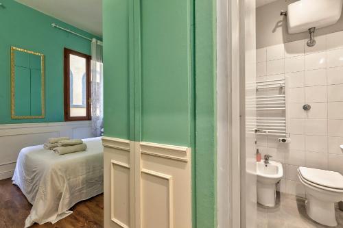 a bathroom with a bed and a toilet and a sink at Santo Spirito Suite in Florence