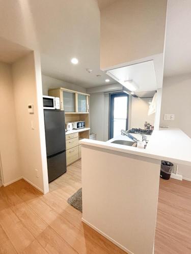 a kitchen with a sink and a refrigerator at Shinkou House UE - Newly Built Secure and Hypoallergenic in Osaka