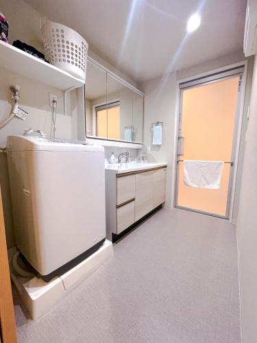 a white bathroom with a sink and a refrigerator at Shinkou House UE - Newly Built Secure and Hypoallergenic in Osaka