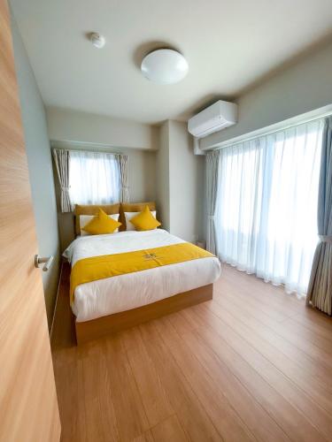 a bedroom with a bed with yellow sheets and yellow pillows at Shinkou House UE - Newly Built Secure and Hypoallergenic in Osaka