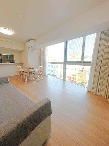 a large living room with a table and a large window at Shinkou House UE - Newly Built Secure and Hypoallergenic in Osaka
