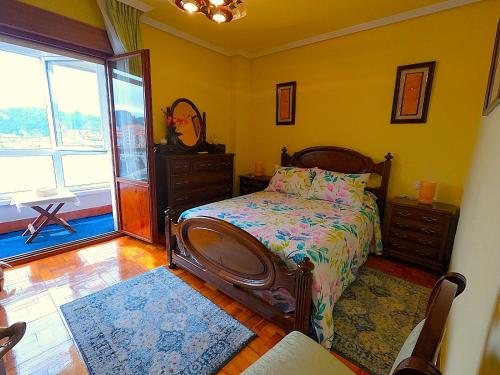 a bedroom with a bed and a large window at El Pescador in Ribadesella