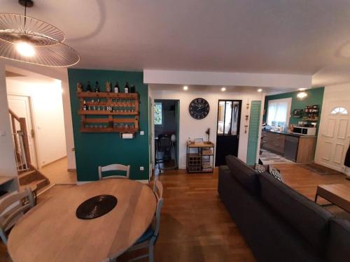 - une salle à manger et un salon avec une table et un canapé dans l'établissement Maison 8 pers proche Le Mans centre, circuit 24H et Boulerie JUMP, à Neuville-sur-Sarthe
