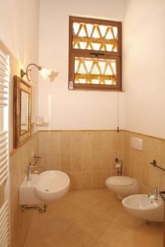 a bathroom with two sinks and two toilets at Agriturismo diffuso Tenuta Armaiolo - widespread farmhouse in Rapolano Terme
