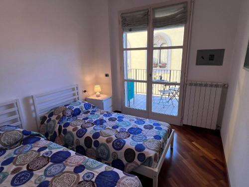 zwei Betten in einem Zimmer mit Blick auf einen Balkon in der Unterkunft Giotto in Verbania