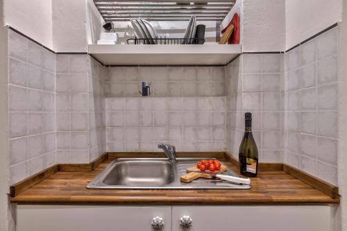 a kitchen with a sink and a bottle of wine at Santo Spirito Suite in Florence