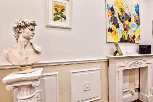 a bust of a woman on a pedestal in a room with paintings at Santo Spirito Suite in Florence