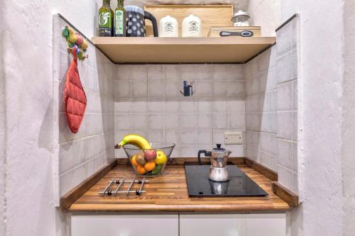 a kitchen with a counter with a bowl of fruit at Santo Spirito Suite in Florence