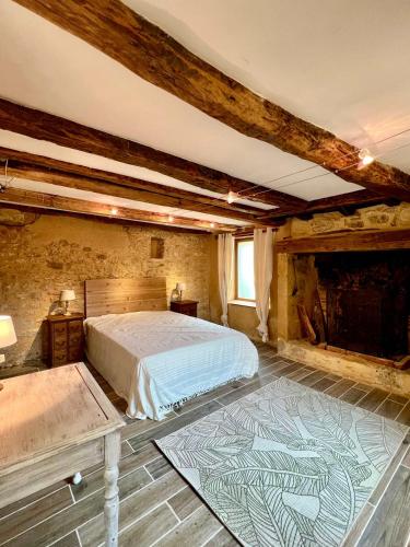 une chambre avec un lit et une cheminée dans l'établissement Charming house for 14 pool and indoor hottub, à Mauzac-et-Grand-Castang