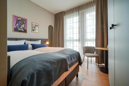 a hotel room with a large bed and a window at INA Boutique Hannover-Linden - Digital Access in Hannover