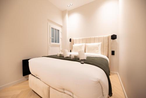 - une chambre avec un grand lit blanc et des oreillers blancs dans l'établissement CIA - Marguerite de Rochechouart, à Paris