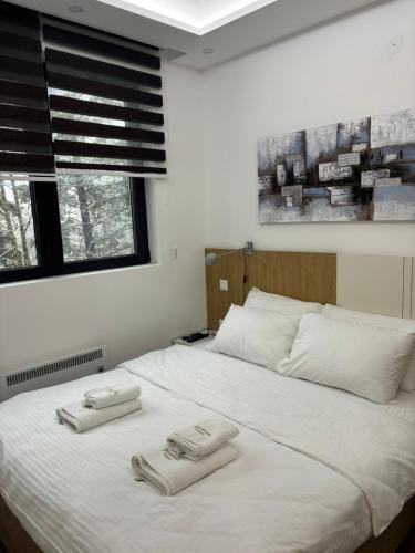 a bedroom with a bed with two towels on it at Zlatiborske terase Spa&Wellness in Zlatibor