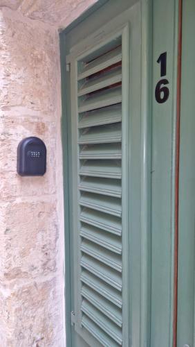 a door with a number on the side of a building at 12 -16 , Pacifiku Scicluna in Birgu