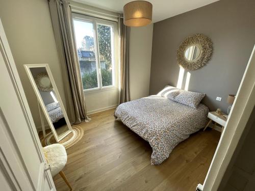 une chambre avec un lit, un miroir et une fenêtre dans l'établissement La Marie-Louise, à Brive-la-Gaillarde