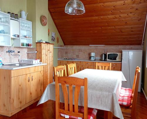 a kitchen with a table and chairs and a refrigerator at Anna Vendégház in Hévíz