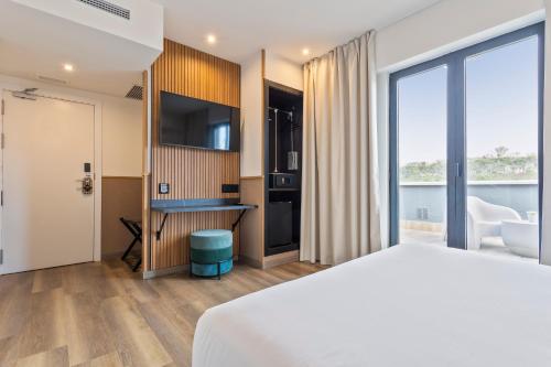a hotel room with a bed and a bathroom at Hotel Acta Madfor in Madrid