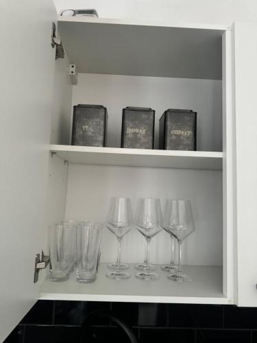 a row of wine glasses sitting on a shelf at Kingston Studio, ideal for professionals relocators and leisure stays, near Kingston Station and Shopping Centre in Kingston upon Thames