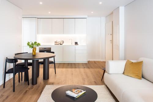 a living room and kitchen with a table and a couch at The Haus - Santa Bárbara II in Lisbon