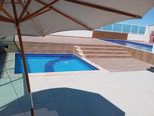 an umbrella in front of a swimming pool at AS PLAZA HOTEL in Paranatama