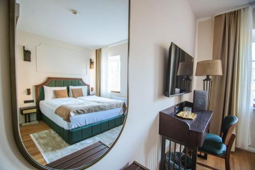 a hotel room with a bed and a mirror at Hotel Ratsmühle Lüneburg in Lüneburg