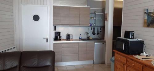 a kitchen with a couch and a tv in a room at AS22244- P4 Vue Mer, sur la plage à 2 pas du Centre Ville avec parking privé in Le Grau-du-Roi