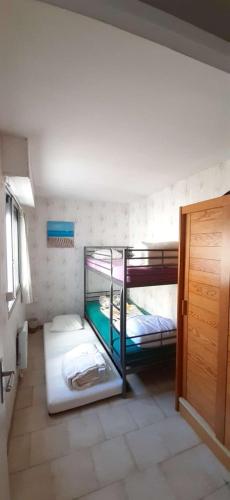 Ce dortoir comprend 2 lits superposés et une porte. dans l'établissement AS22244- P4 Vue Mer, sur la plage à 2 pas du Centre Ville avec parking privé, au Grau-du-Roi