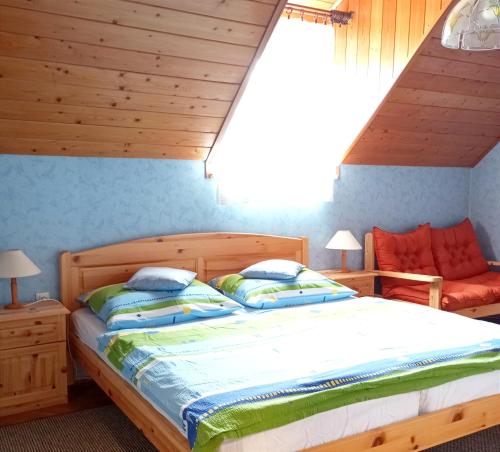 a bedroom with a large bed with a wooden headboard at Anna Vendégház in Hévíz