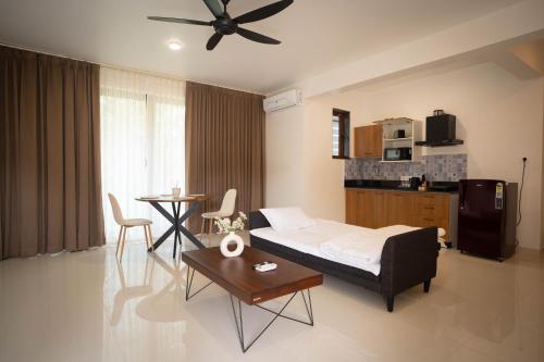 a bedroom with a bed and a table and a kitchen at Mistral by the sea in Benaulim