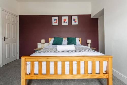 een slaapkamer met een houten bed met groene kussens bij Modern 4-Bed Home Sleeps 6 in Stockton-on-Tees