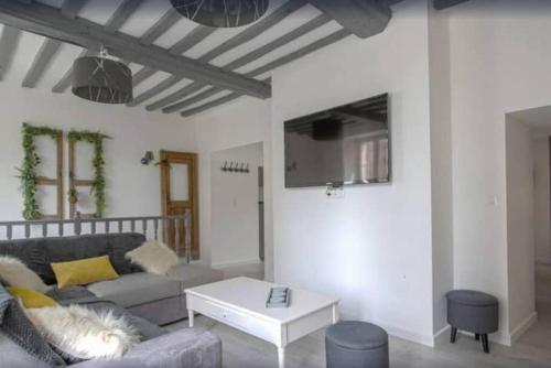 un salon avec un canapé et une table dans l'établissement La maison d'Eden - WEEKEND / HOLIDAY - WIFI / TV, à Bayeux