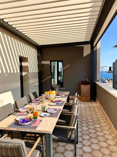 a dining room with a long table and chairs at Villa AYA in Riposto