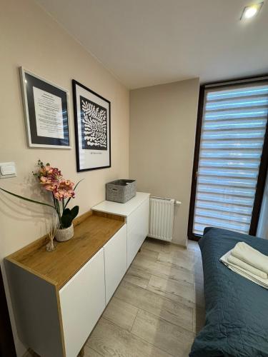 a bedroom with a desk with flowers on it at Aparthotel Riva in Zawiercie