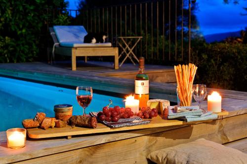 - une table avec de la nourriture, des bougies et une bouteille de vin dans l'établissement Les bergeries alivaccia, à Figari