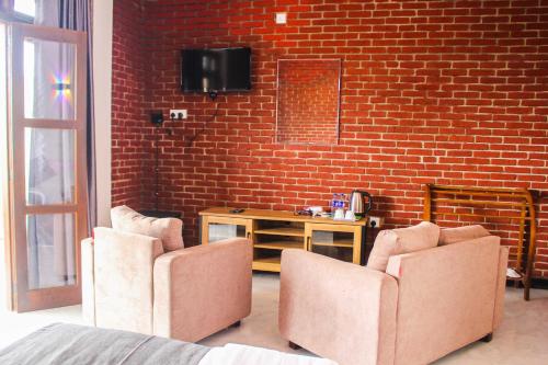 a living room with two chairs and a brick wall at Nature Rock Ella in Ella