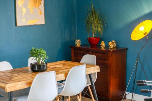 a dining room with a wooden table and white chairs at Le Saintonge #Jardin#Calme in Châteaubernard