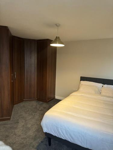 a bedroom with a large bed and a cabinet at Stylish Home 5 Mins to City Center in Manchester