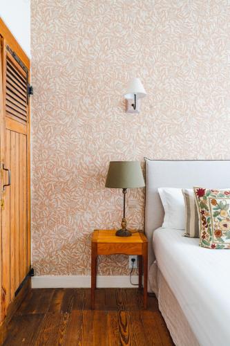 a bedroom with a bed and a table with a lamp at Hotel Edouard VII in Biarritz