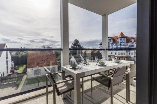 a dining room with a table and chairs on a balcony at De Branding A21 in Cadzand